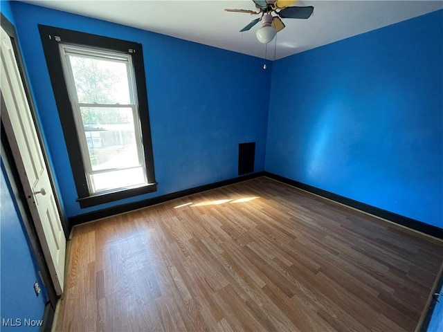 unfurnished room with ceiling fan and wood-type flooring