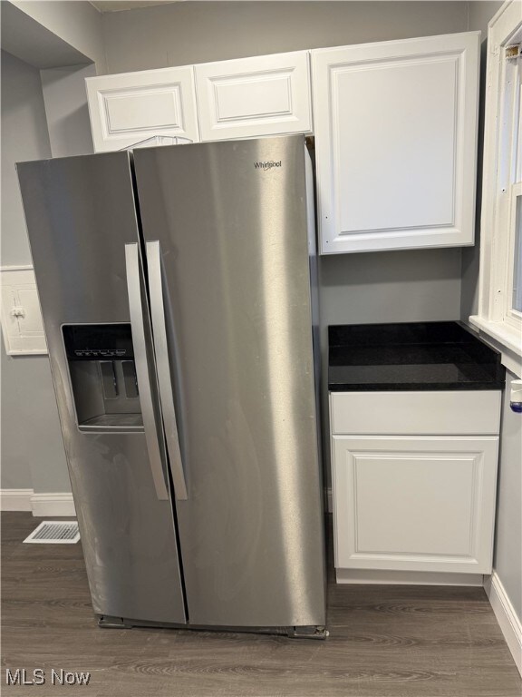 kitchen with white cabinets, stainless steel fridge, and dark hardwood / wood-style floors