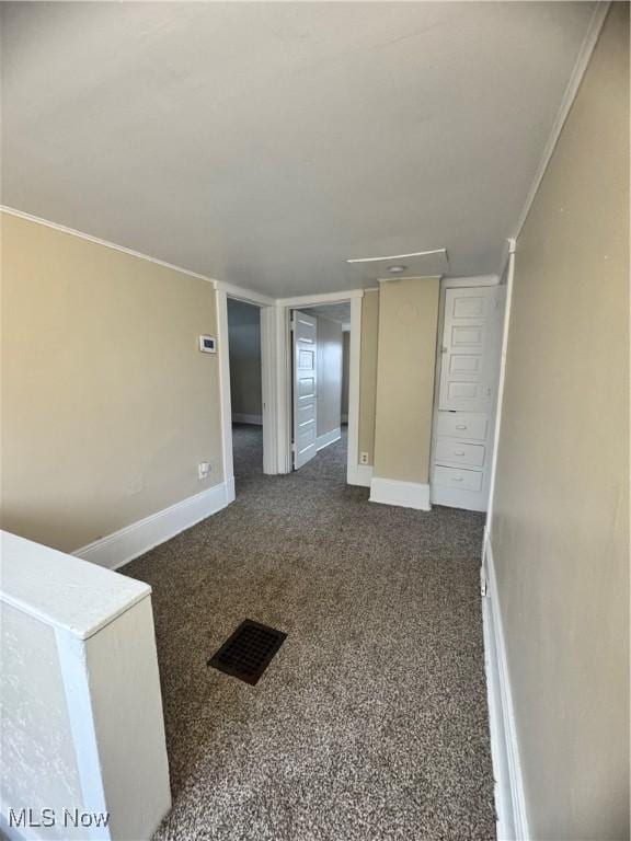 spare room with dark carpet and crown molding