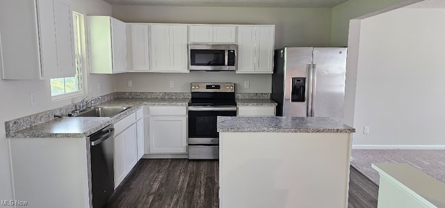 kitchen with appliances with stainless steel finishes, a textured ceiling, dark wood-type flooring, sink, and white cabinetry