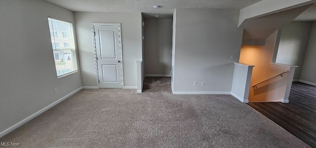 carpeted spare room with a textured ceiling