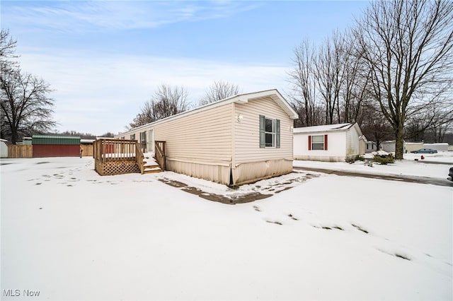 snow covered property featuring a wooden deck