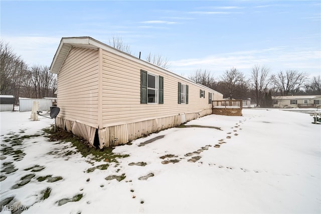 view of snowy exterior with a deck