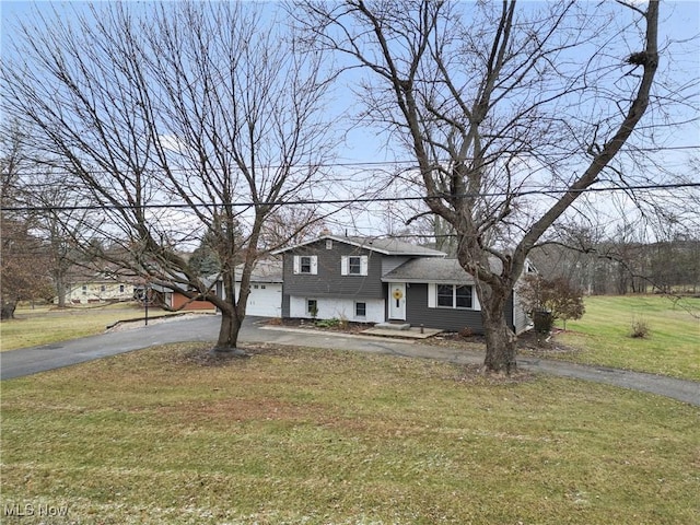 tri-level home featuring a front yard and a garage