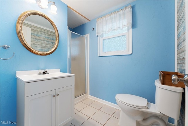 bathroom with tile patterned flooring, vanity, a shower with shower door, and toilet