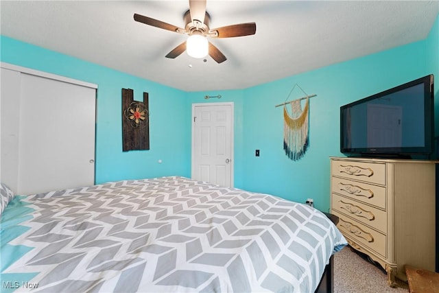 bedroom with a closet, ceiling fan, and light colored carpet