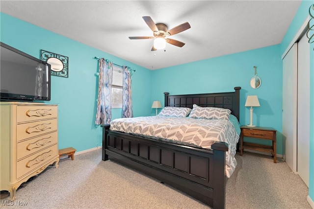 carpeted bedroom with ceiling fan and a closet