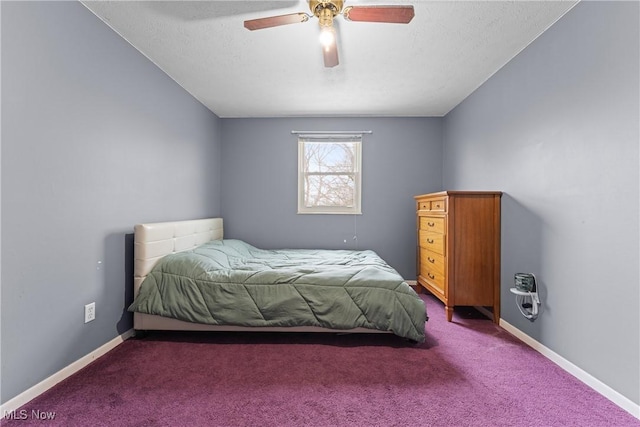 bedroom with dark colored carpet, a textured ceiling, and ceiling fan