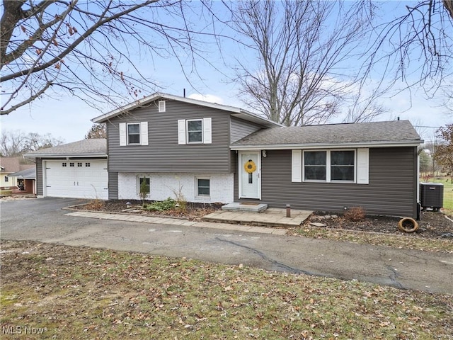 split level home featuring central AC and a garage