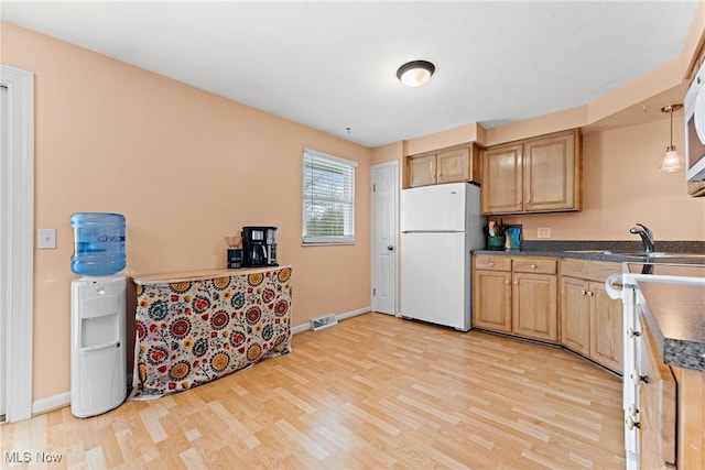 kitchen featuring white refrigerator, sink, and light hardwood / wood-style flooring