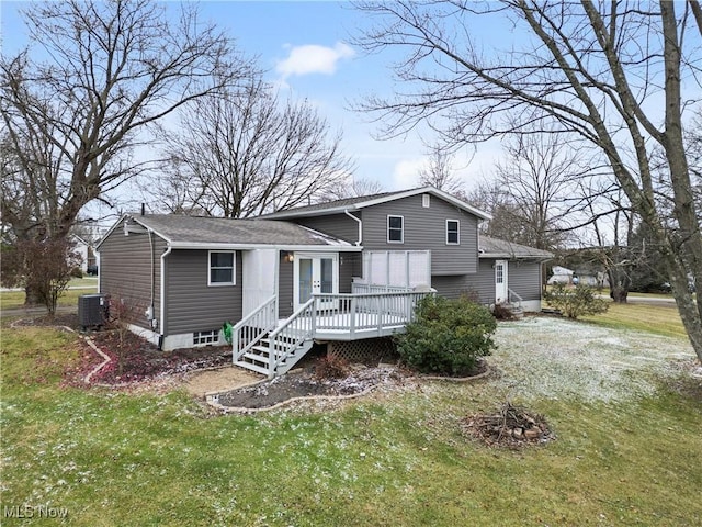 back of property with a lawn, a deck, and central AC