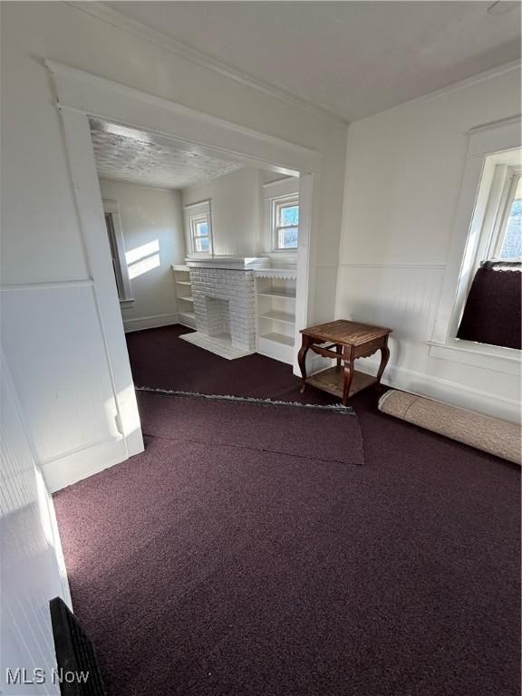 misc room with dark colored carpet and crown molding