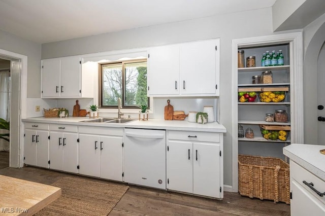 kitchen with white cabinets, dark hardwood / wood-style flooring, white dishwasher, and sink