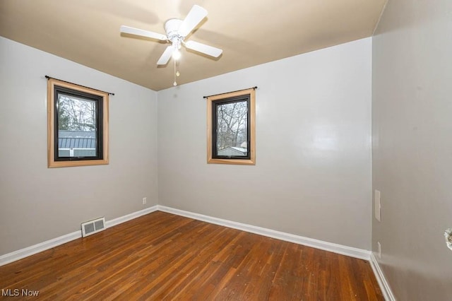 unfurnished room with ceiling fan and dark hardwood / wood-style flooring