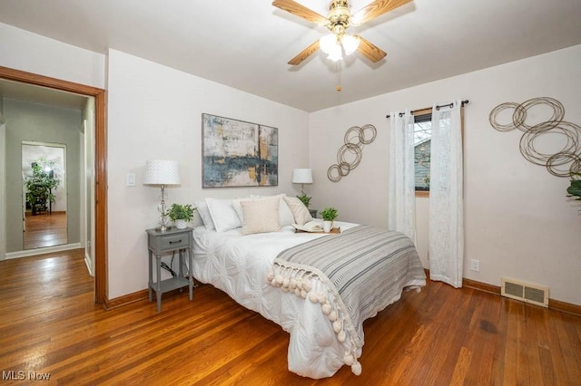 bedroom with dark hardwood / wood-style flooring and ceiling fan