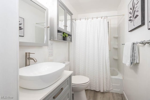 full bathroom featuring shower / bath combo with shower curtain, vanity, wood-type flooring, and toilet