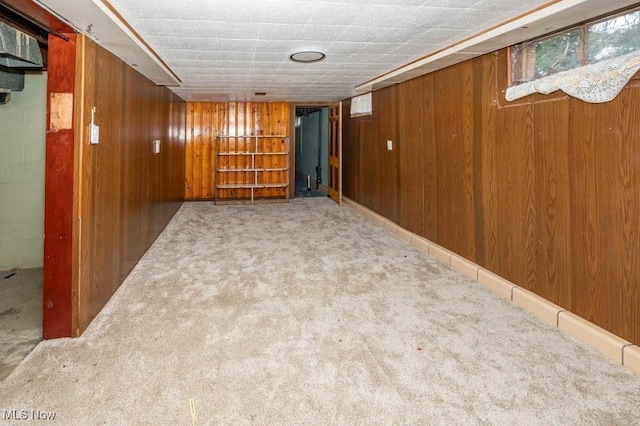 basement featuring carpet flooring and wooden walls