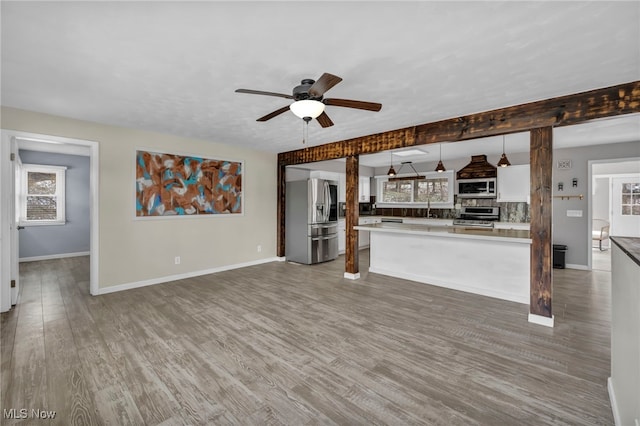 unfurnished living room with ceiling fan and dark hardwood / wood-style flooring