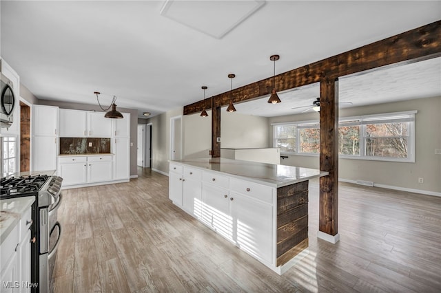 kitchen featuring appliances with stainless steel finishes, a center island, light hardwood / wood-style floors, and white cabinetry