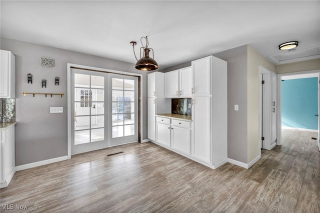 kitchen featuring backsplash, white cabinets, and light hardwood / wood-style floors