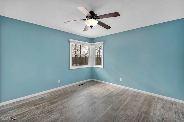 empty room with ceiling fan and wood-type flooring