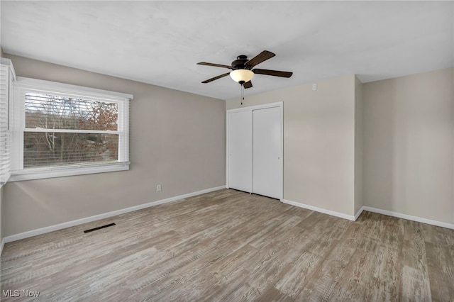 unfurnished bedroom featuring a closet, ceiling fan, and light hardwood / wood-style flooring