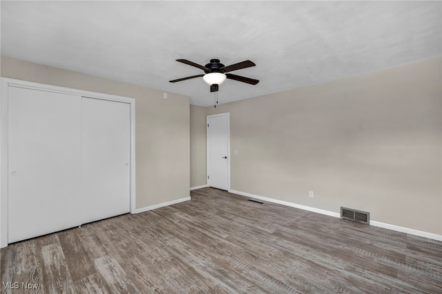 unfurnished bedroom with a closet, ceiling fan, and hardwood / wood-style floors