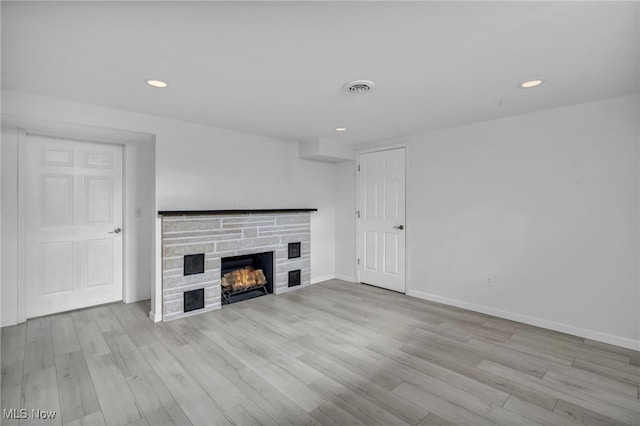 unfurnished living room with a fireplace and light hardwood / wood-style flooring