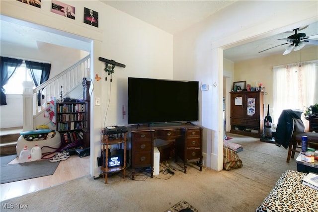 carpeted living room with ceiling fan