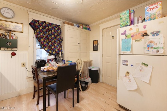 dining room with light hardwood / wood-style flooring and ornamental molding