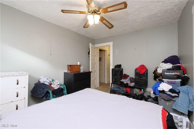 bedroom featuring ceiling fan and a textured ceiling