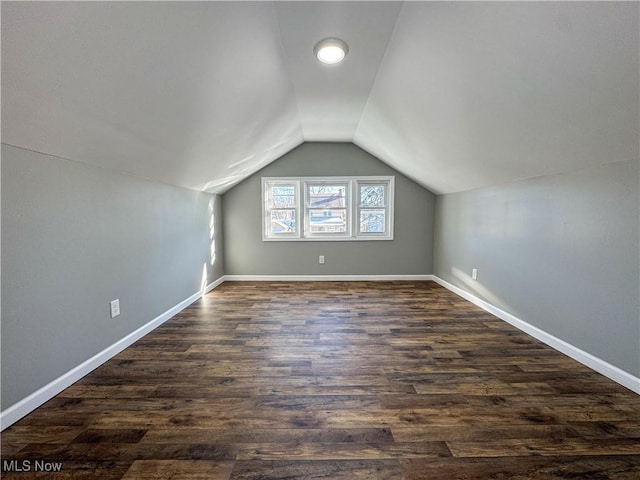 bonus room with dark wood-type flooring and lofted ceiling