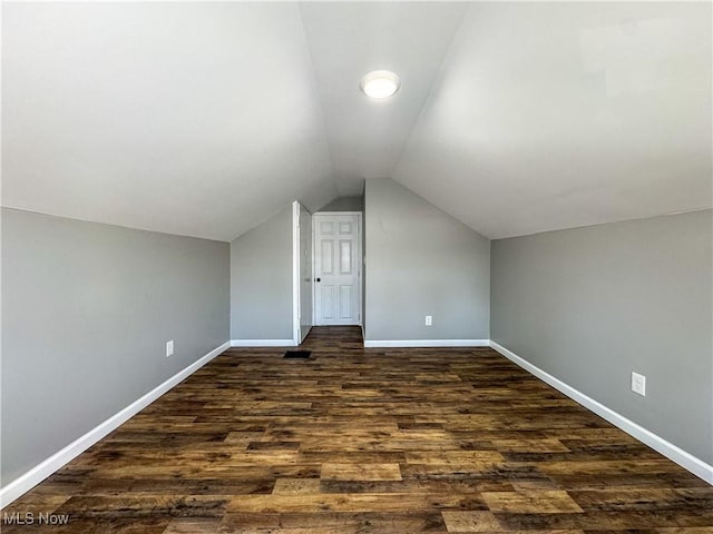 additional living space featuring lofted ceiling and dark hardwood / wood-style floors