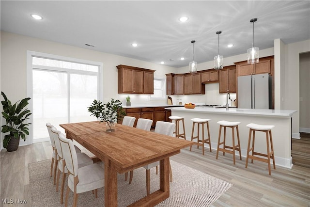 dining room featuring light hardwood / wood-style flooring, a healthy amount of sunlight, and sink