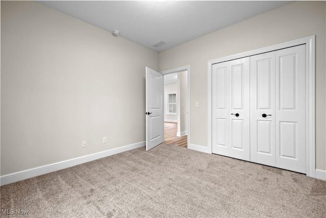 unfurnished bedroom featuring carpet and a closet