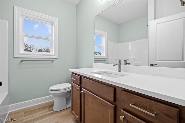 full bathroom with hardwood / wood-style flooring, vanity,  shower combination, and toilet