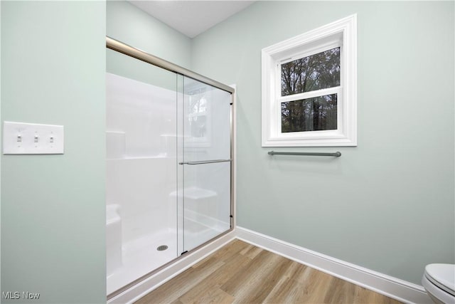 bathroom with toilet, wood-type flooring, and walk in shower