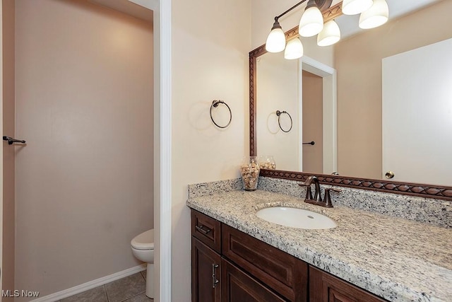 bathroom with tile patterned flooring, vanity, and toilet