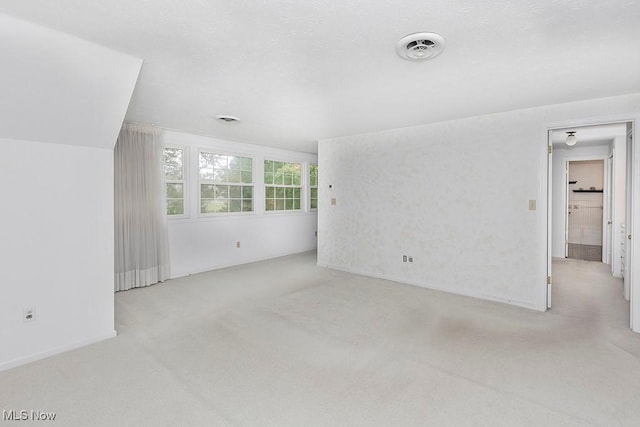 unfurnished living room featuring light colored carpet