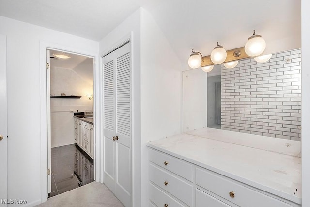 bathroom with vanity and lofted ceiling