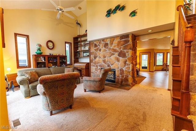 living room featuring a fireplace, ceiling fan, hardwood / wood-style floors, and high vaulted ceiling