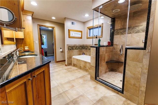 bathroom with tile patterned flooring, vanity, and shower with separate bathtub