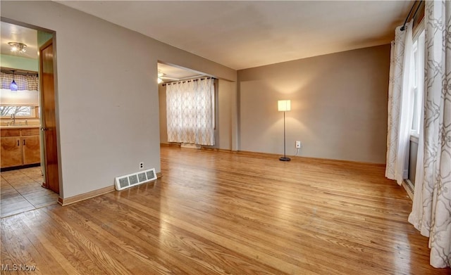 spare room with light wood-type flooring and sink