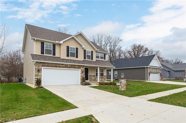 view of front of home featuring covered porch, a garage, and a front lawn