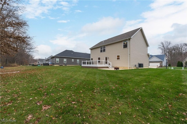 rear view of house featuring central air condition unit, a deck, and a lawn