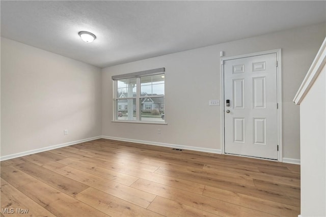 interior space featuring a textured ceiling and light wood-type flooring