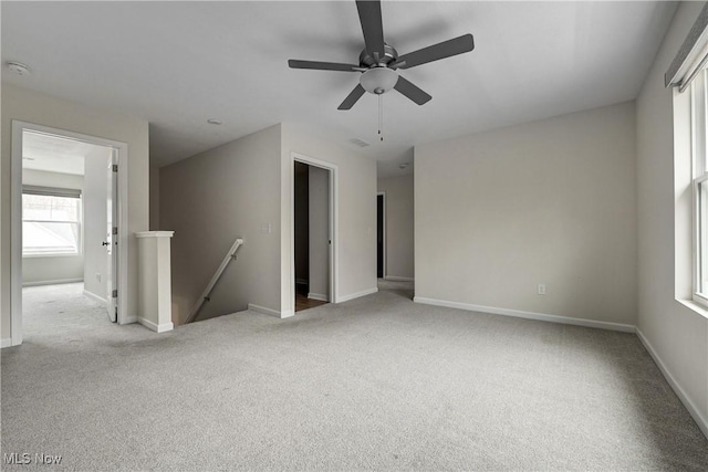 carpeted spare room featuring ceiling fan