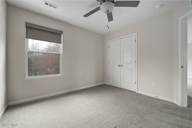 unfurnished bedroom with carpet, a closet, and ceiling fan