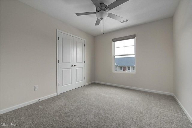 unfurnished bedroom with carpet, ceiling fan, and a closet