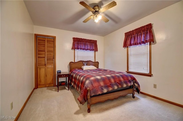 carpeted bedroom with ceiling fan, a closet, and multiple windows